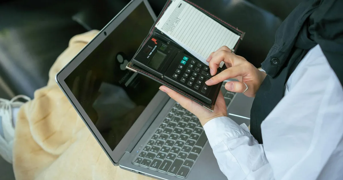 ZZP-er controleert boekhouding op laptop met calculator