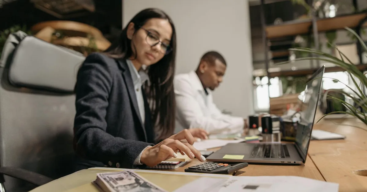 Twee professionals werken samen aan boekhouding op laptop — Exact Online review voor ZZP'ers