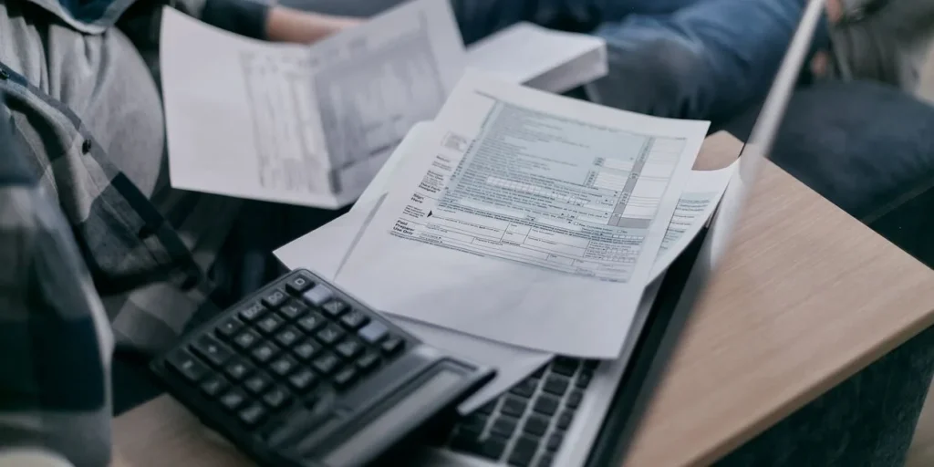 Freelancer vergelijkt Moneybird en Snelstart met calculator en laptop